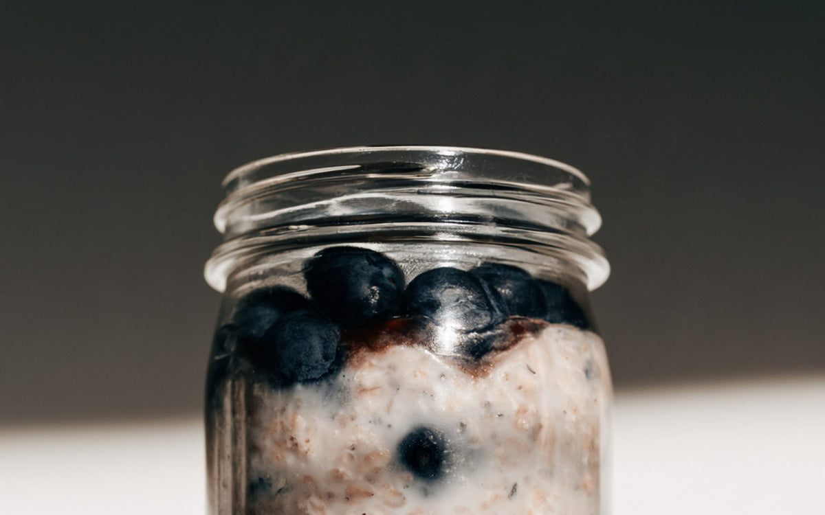A glass jar of overnight oats with blueberries